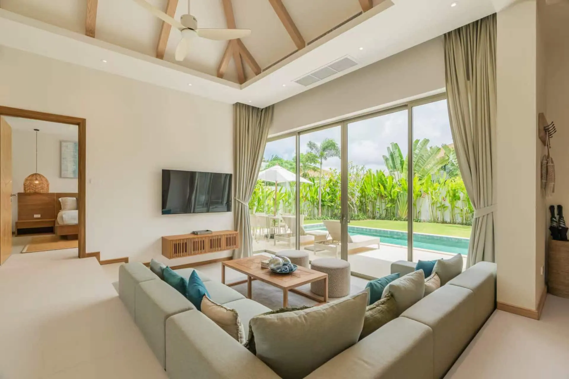 Living room with a large sofa and glass doors opening to the pool