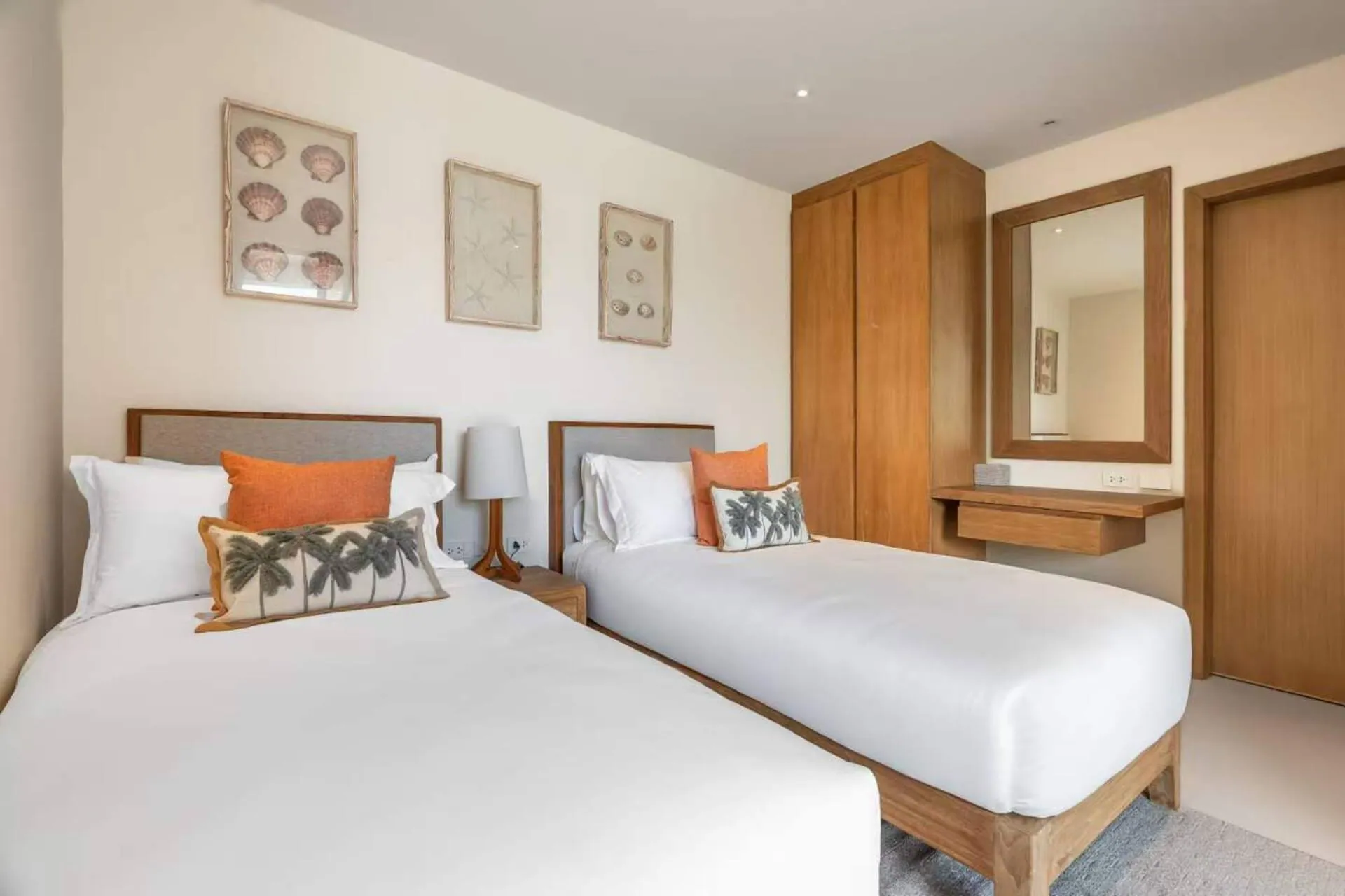 Twin bedroom with two single beds and framed shell prints