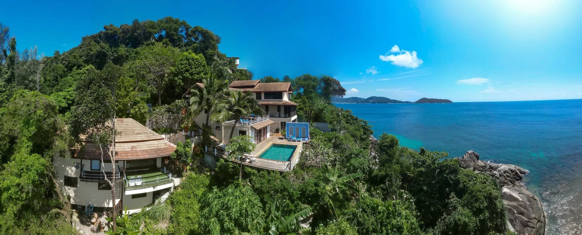 Aerial view of the villa on a wooded hillside above the sea