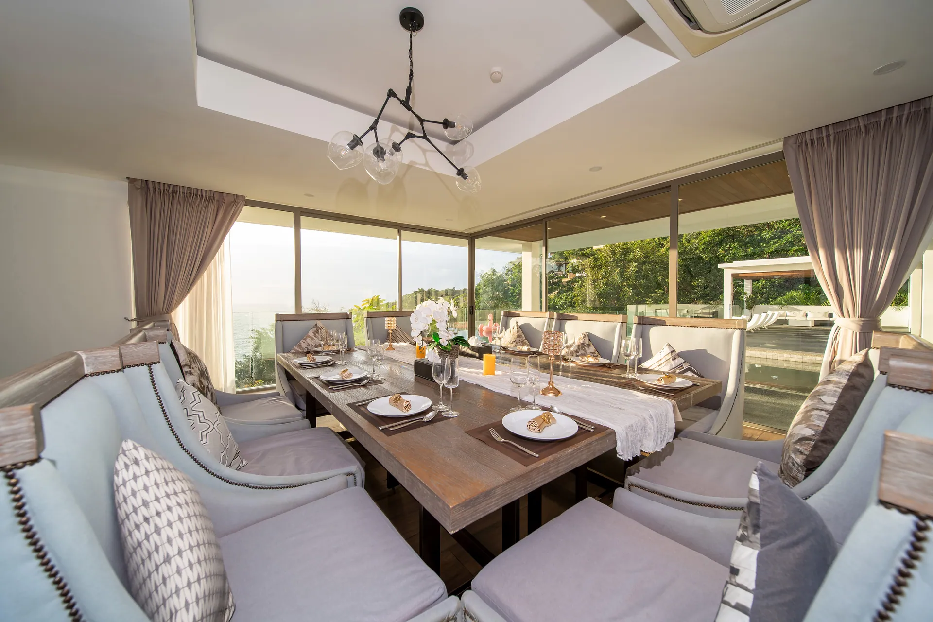 Long dining table beside floor-to-ceiling windows