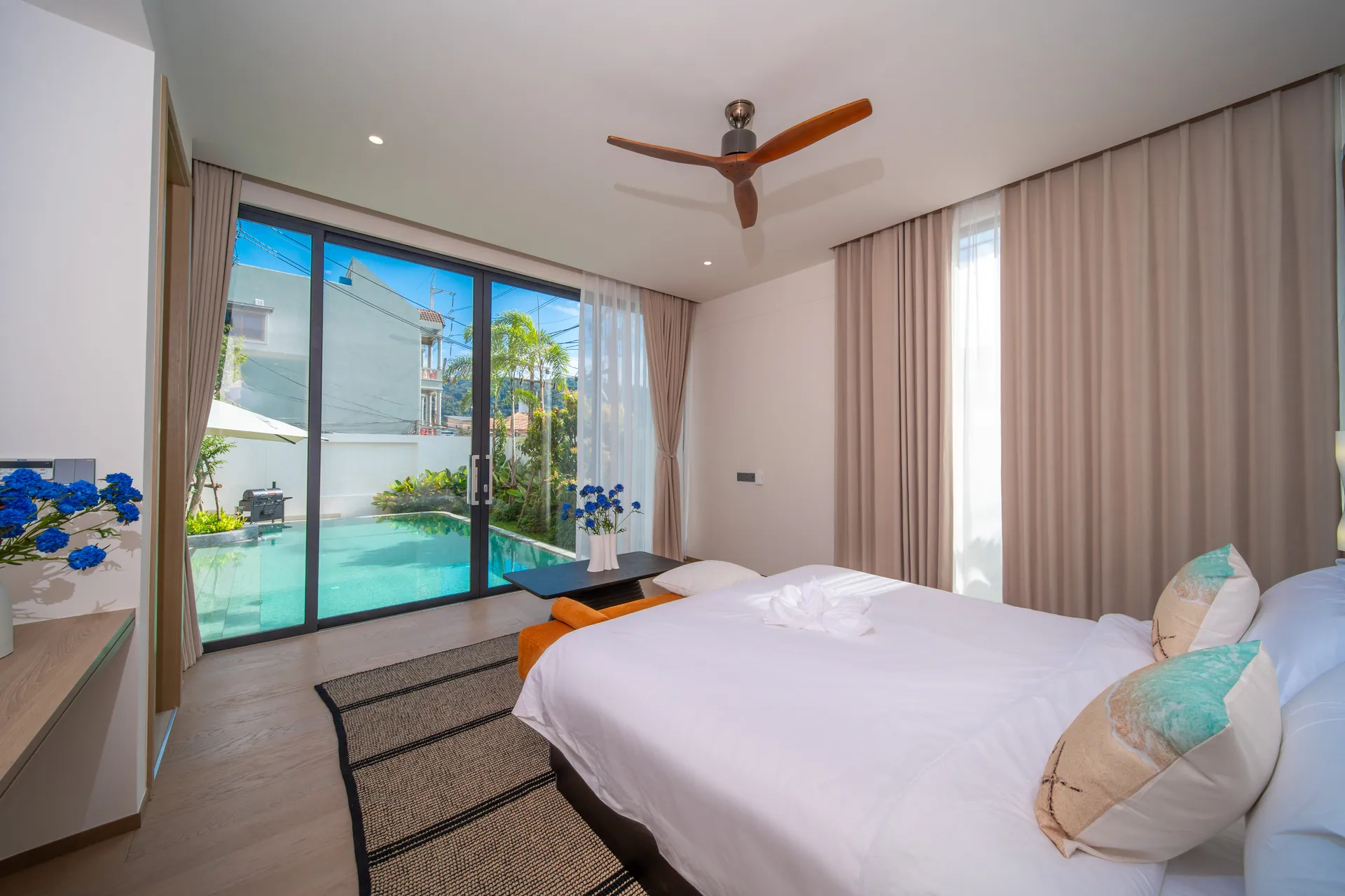 Bedroom with a king bed and floor-to-ceiling glass doors onto the pool