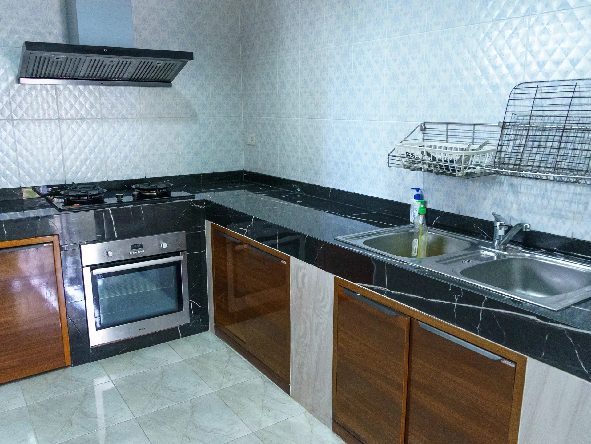 Kitchen with a hob, built-in oven, double sink and black stone worktops