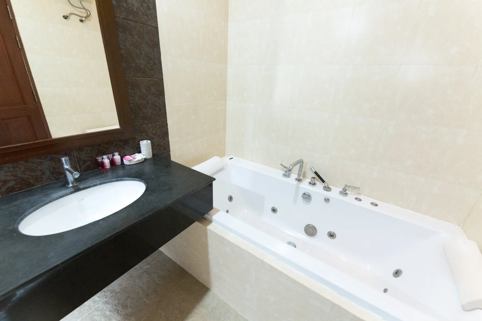 Bathroom with a black stone vanity and a jetted bathtub