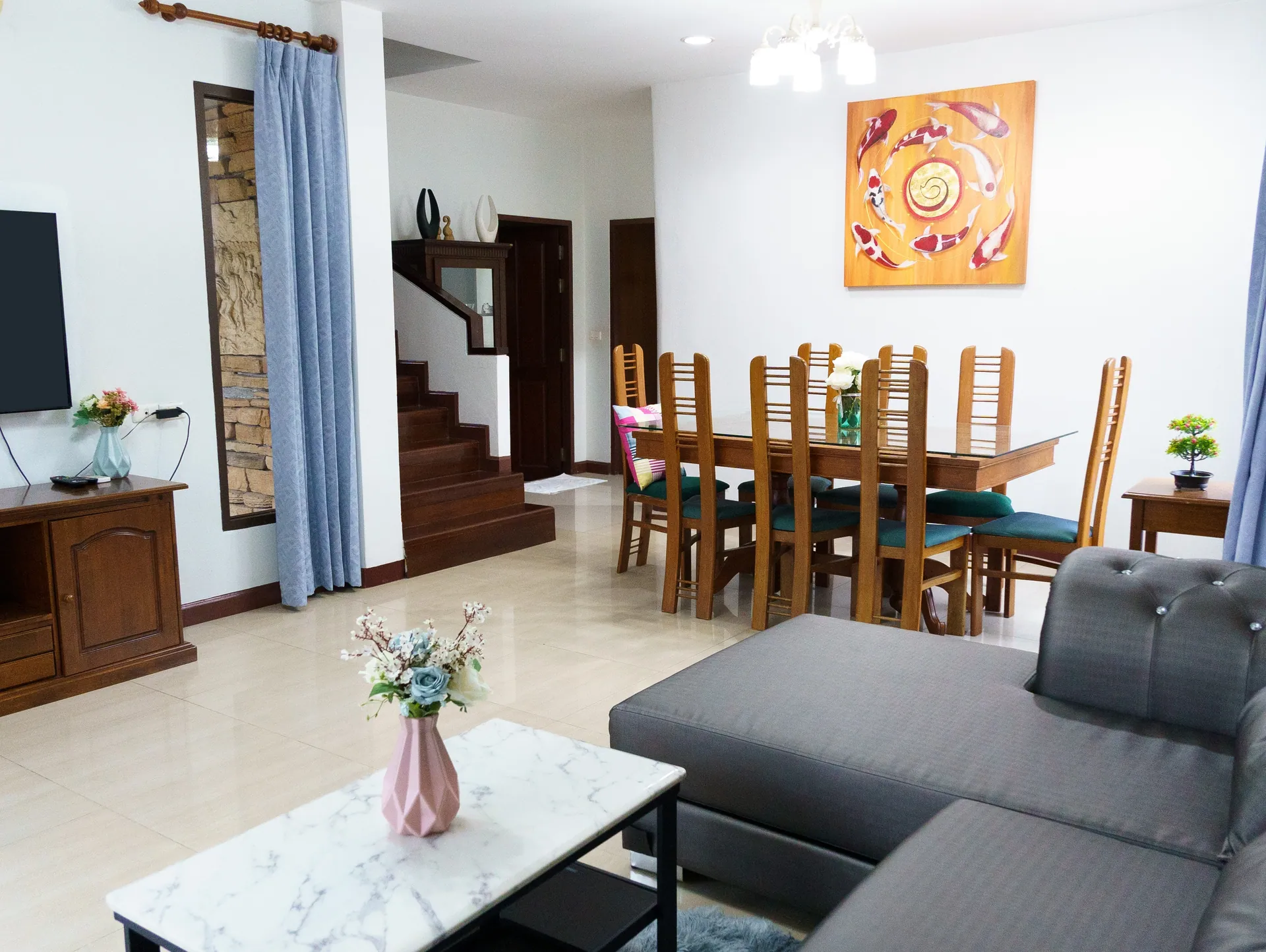 Long wooden dining table beside the staircase, seen across the living room