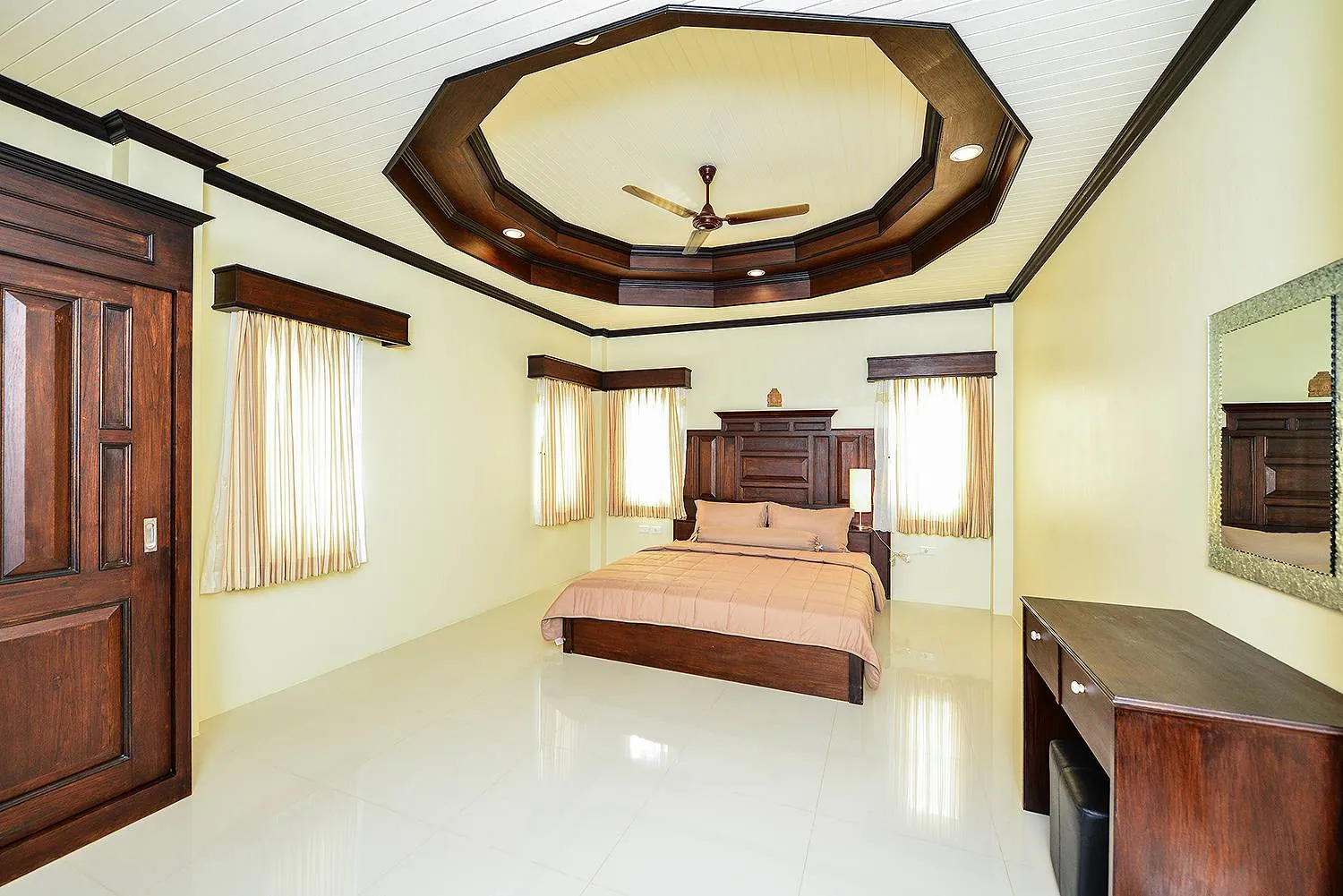 Bedroom with a king bed centred under an octagonal tray ceiling