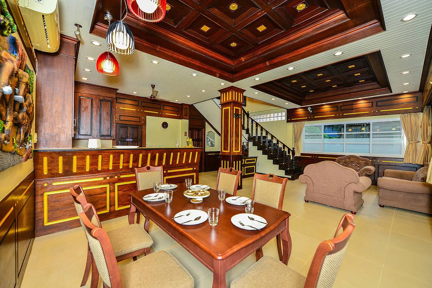 Dining table laid for a meal beside the lounge, under a coffered wood ceiling