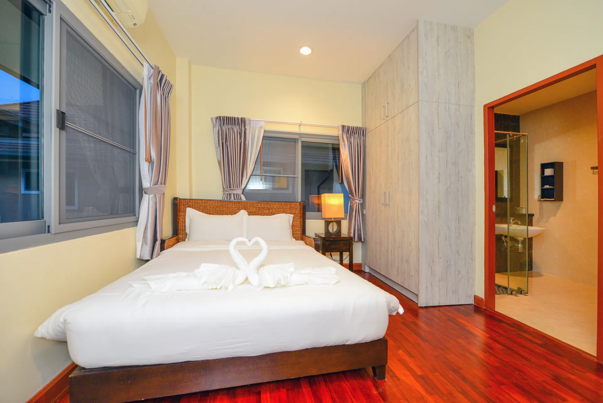 Bedroom with a king bed, a tall wardrobe and a doorway to its own shower room