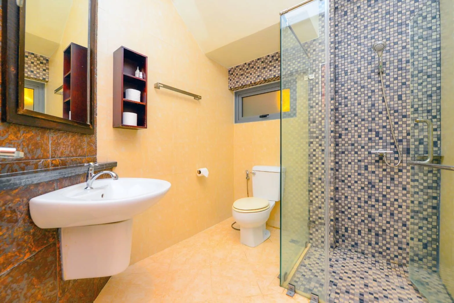 Bathroom with a glass-screened shower, mosaic tiles, a basin and a toilet