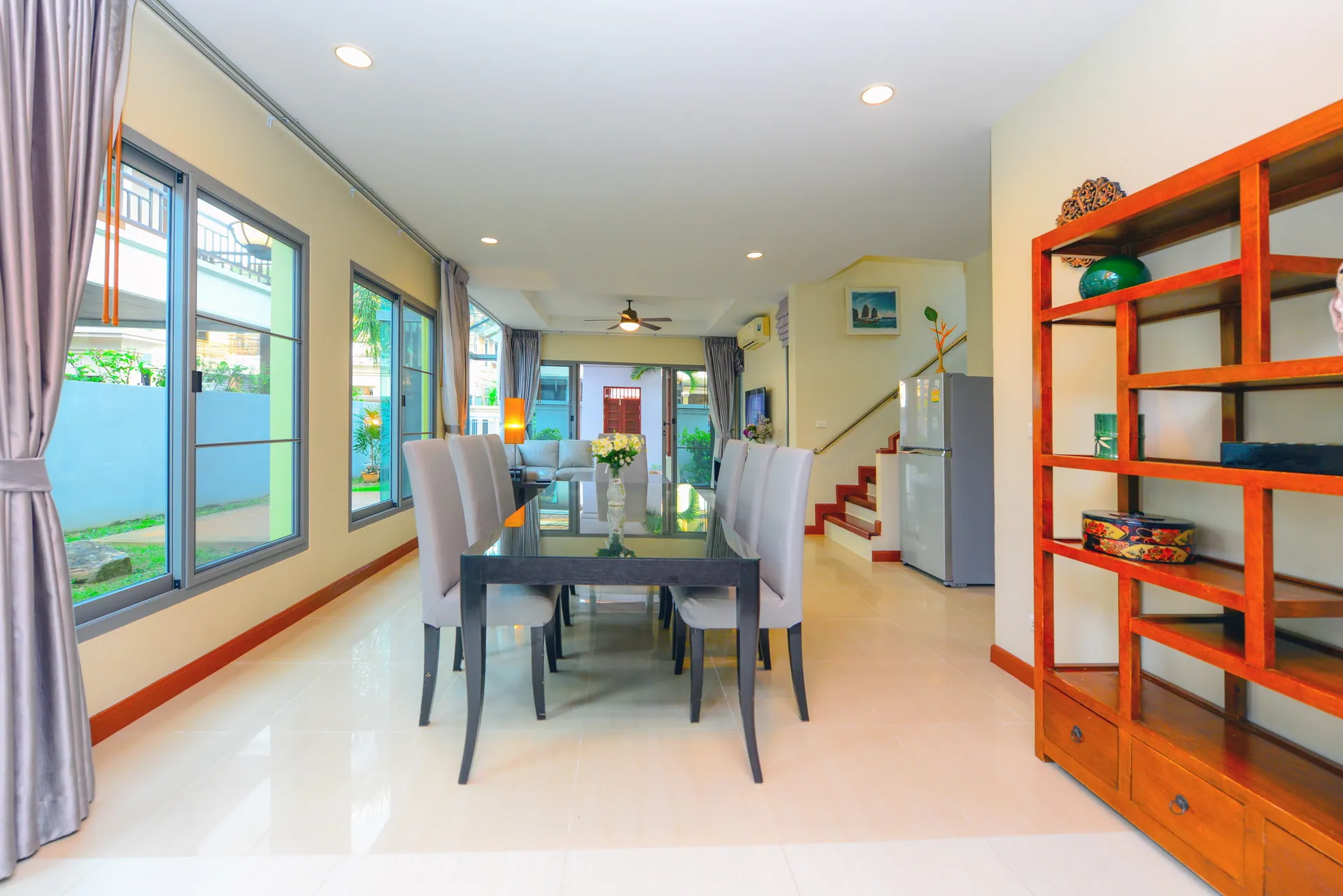 Open-plan ground floor with the dining table, a wooden display shelf and the staircase beyond