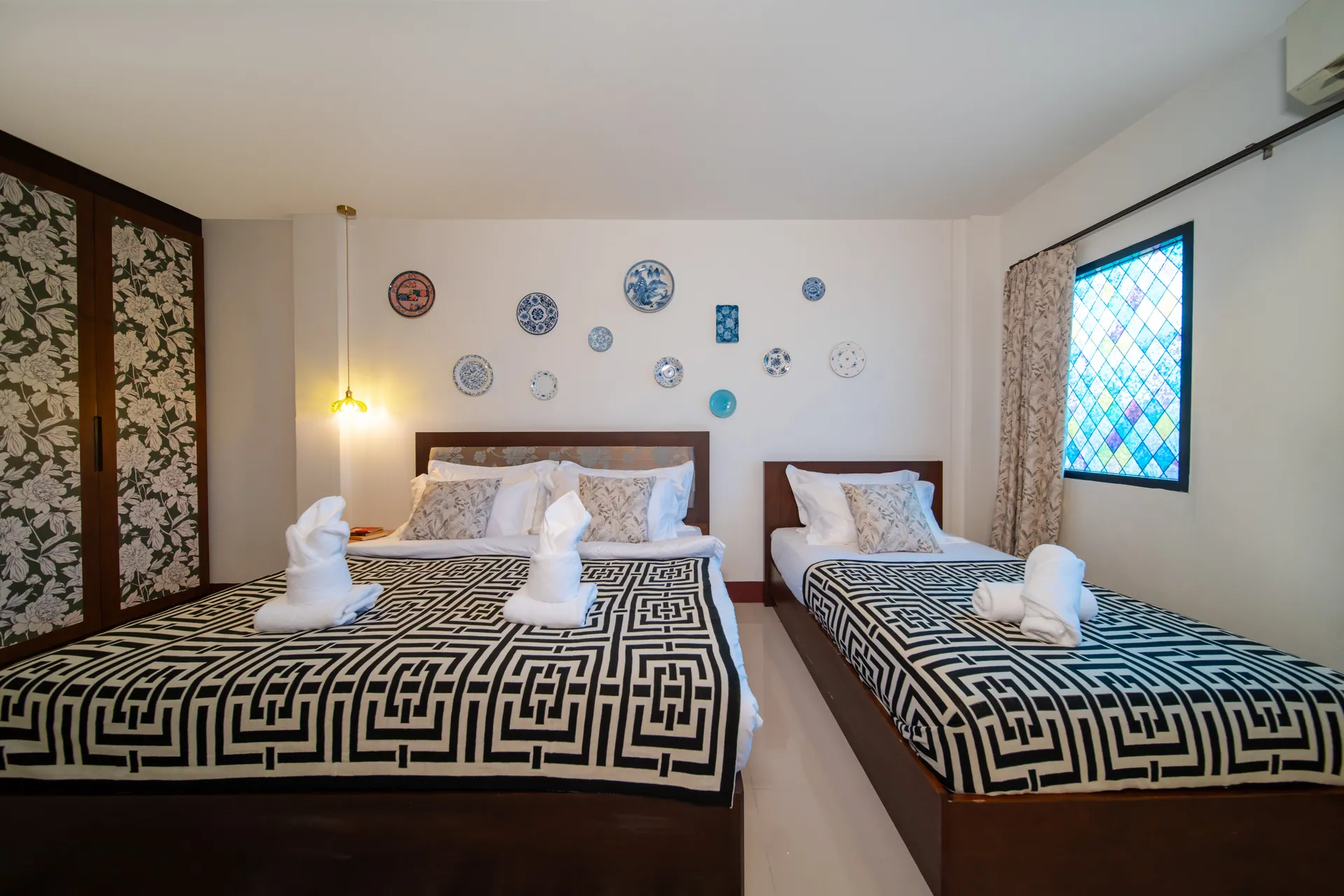 Triple Room with a king bed and a single bed side by side under porcelain wall plates