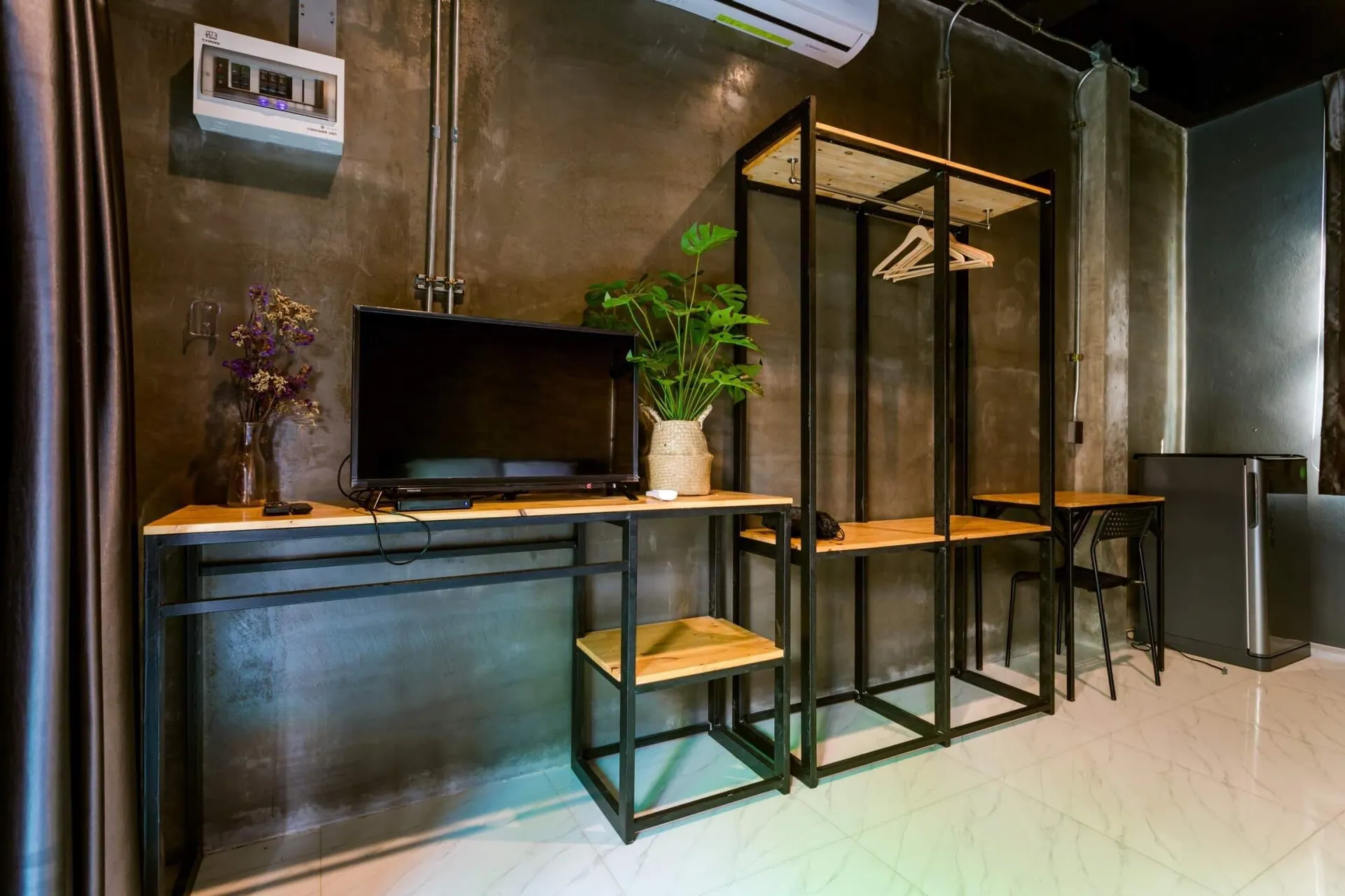 Work desk with a TV, open wardrobe rail and shelving in steel and timber