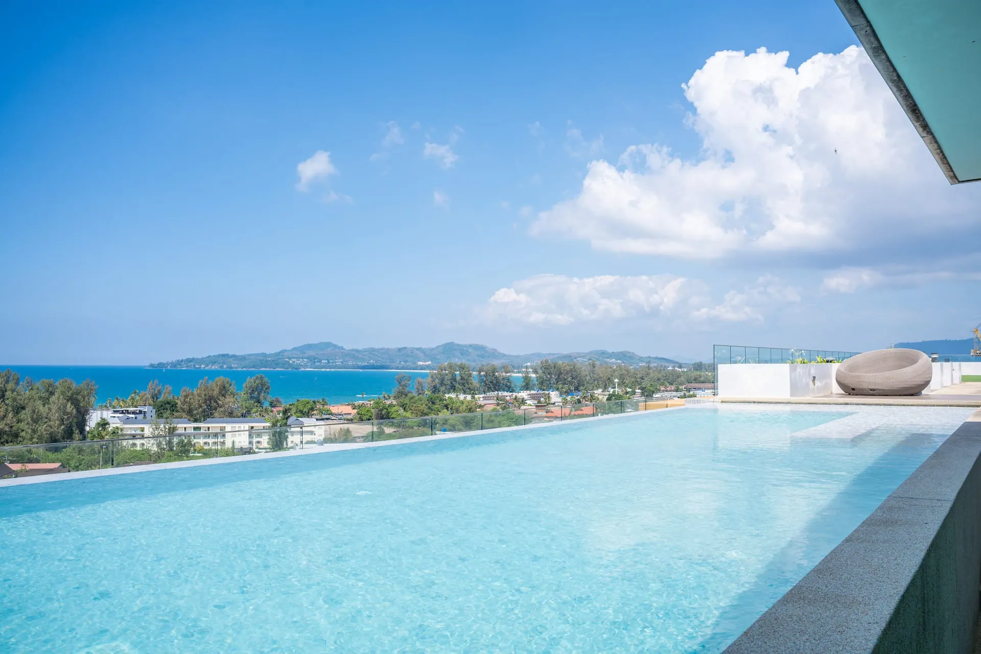 Infinity edge of the rooftop pool, with the sea and distant headlands on the horizon