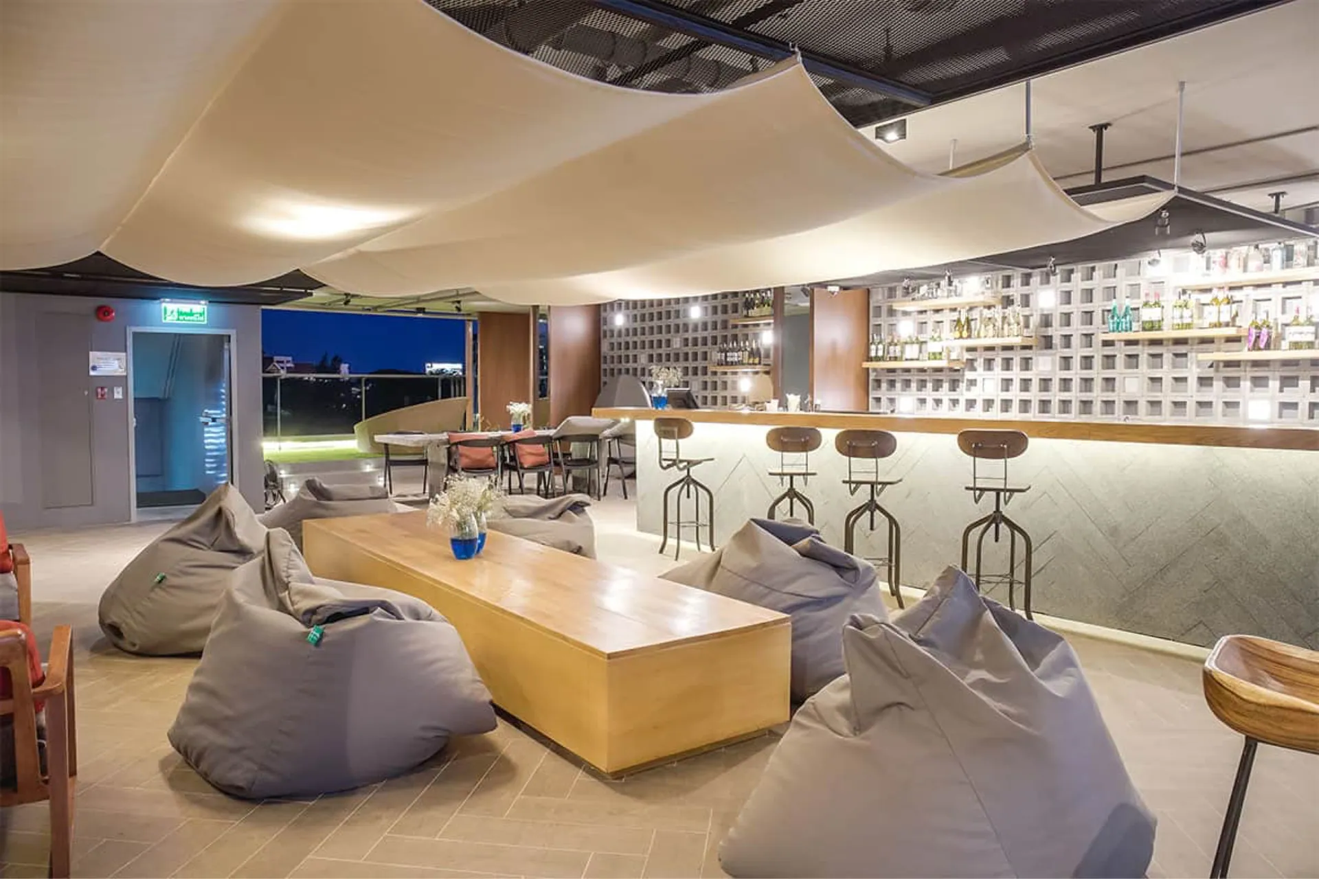 Lounge with beanbags, a low timber table and a bar counter with stools