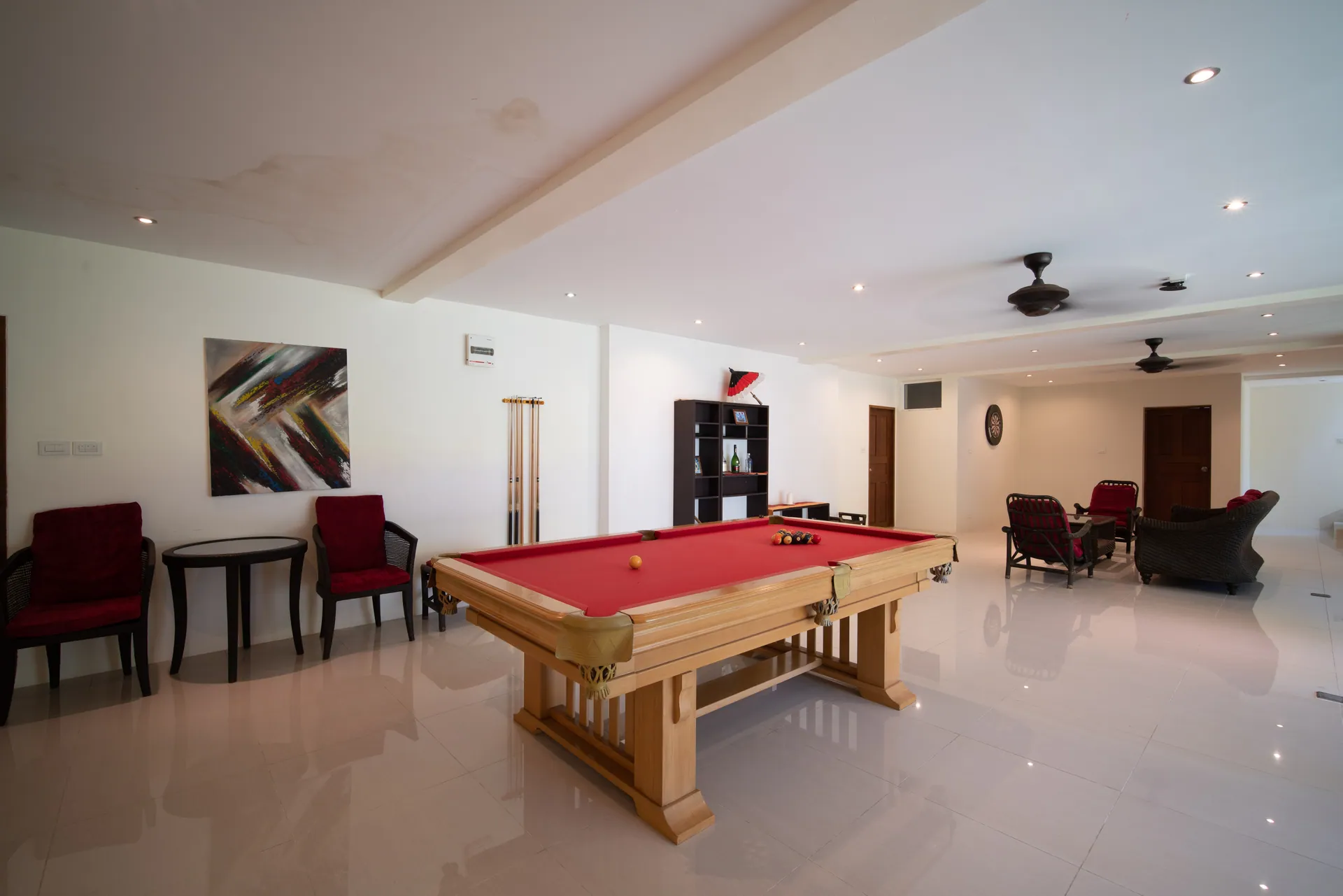 Games room with a pool table, a cue rack and lounge chairs