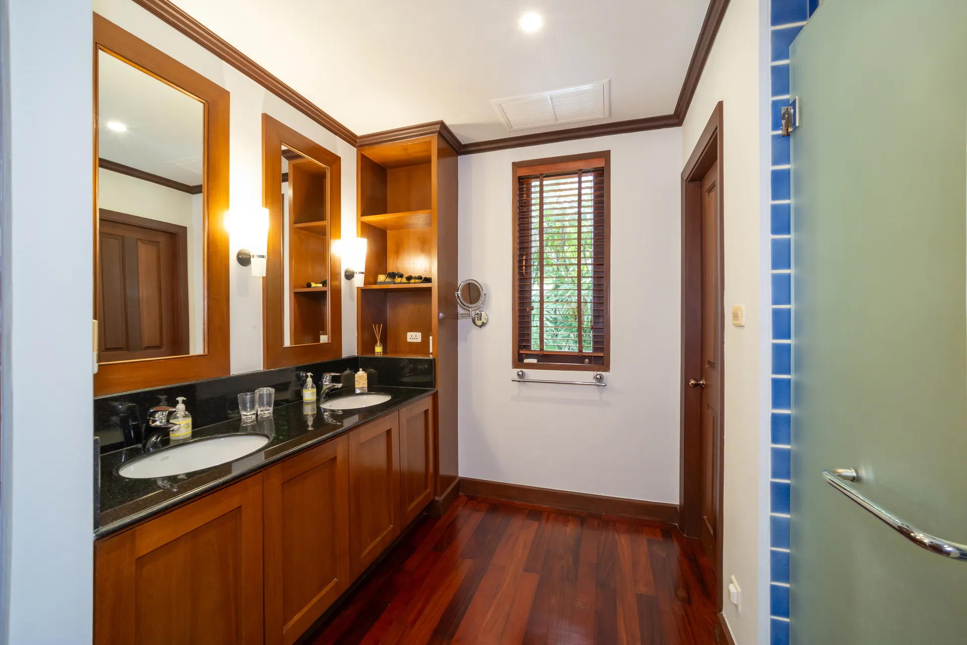 Bathroom with a twin-basin vanity in timber and dark granite