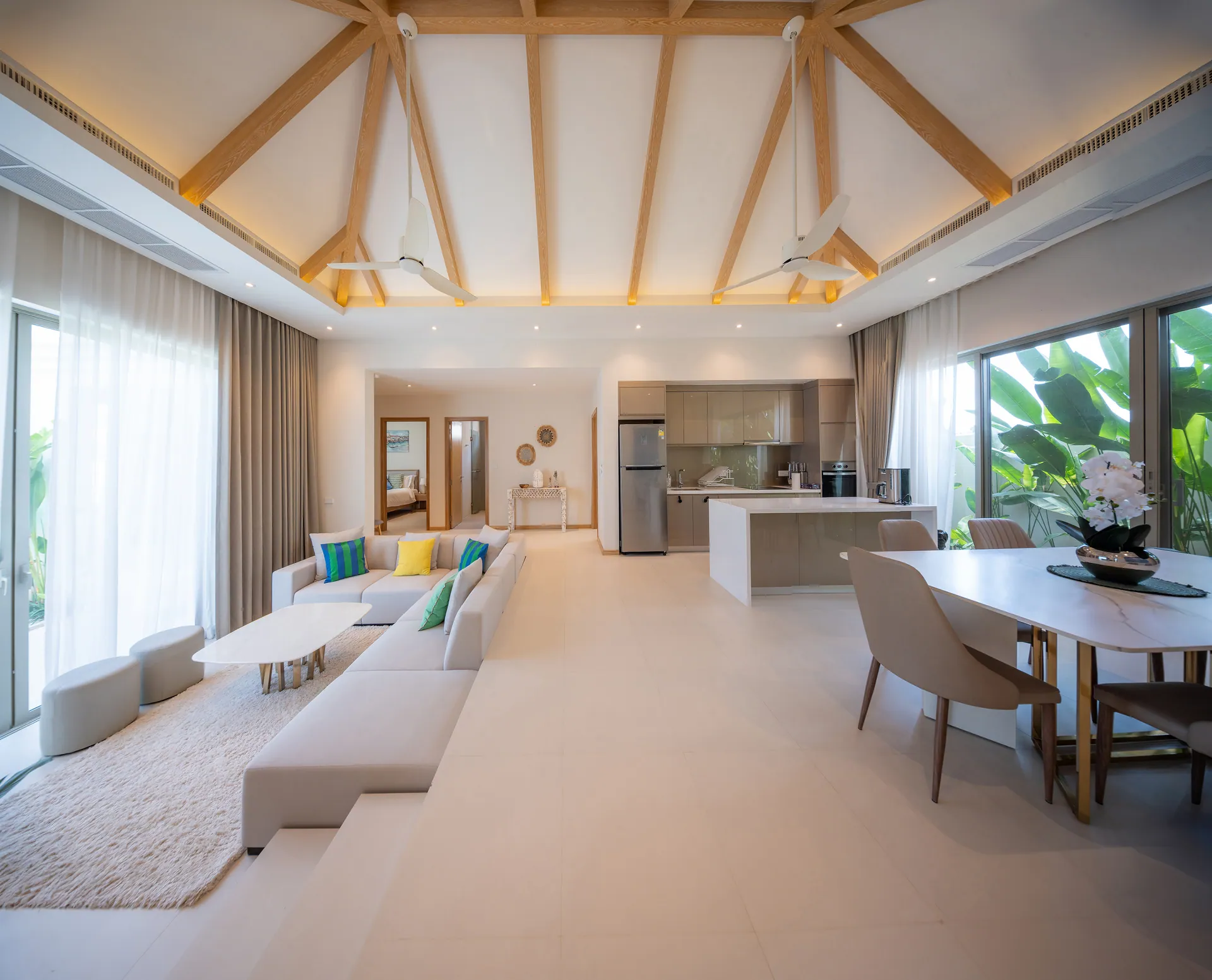 Open-plan living, dining and kitchen area under a vaulted, timber-beamed ceiling