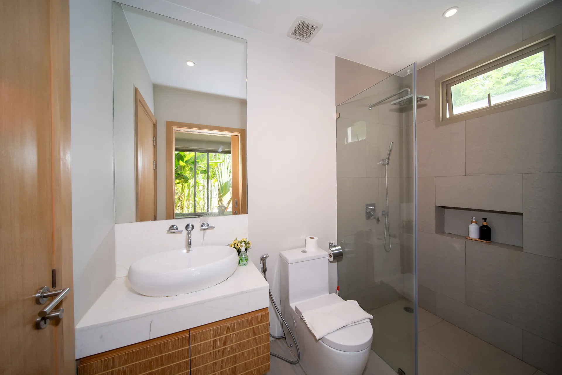 Bathroom with a glass-screened shower, a vessel basin and a high window to the garden