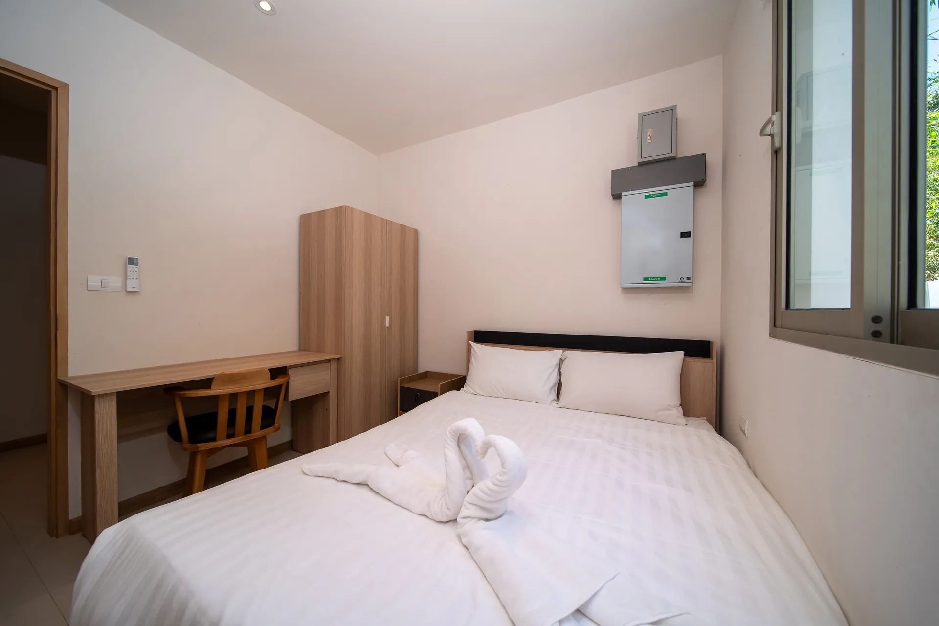 Smaller bedroom with a double bed, a writing desk and a wardrobe