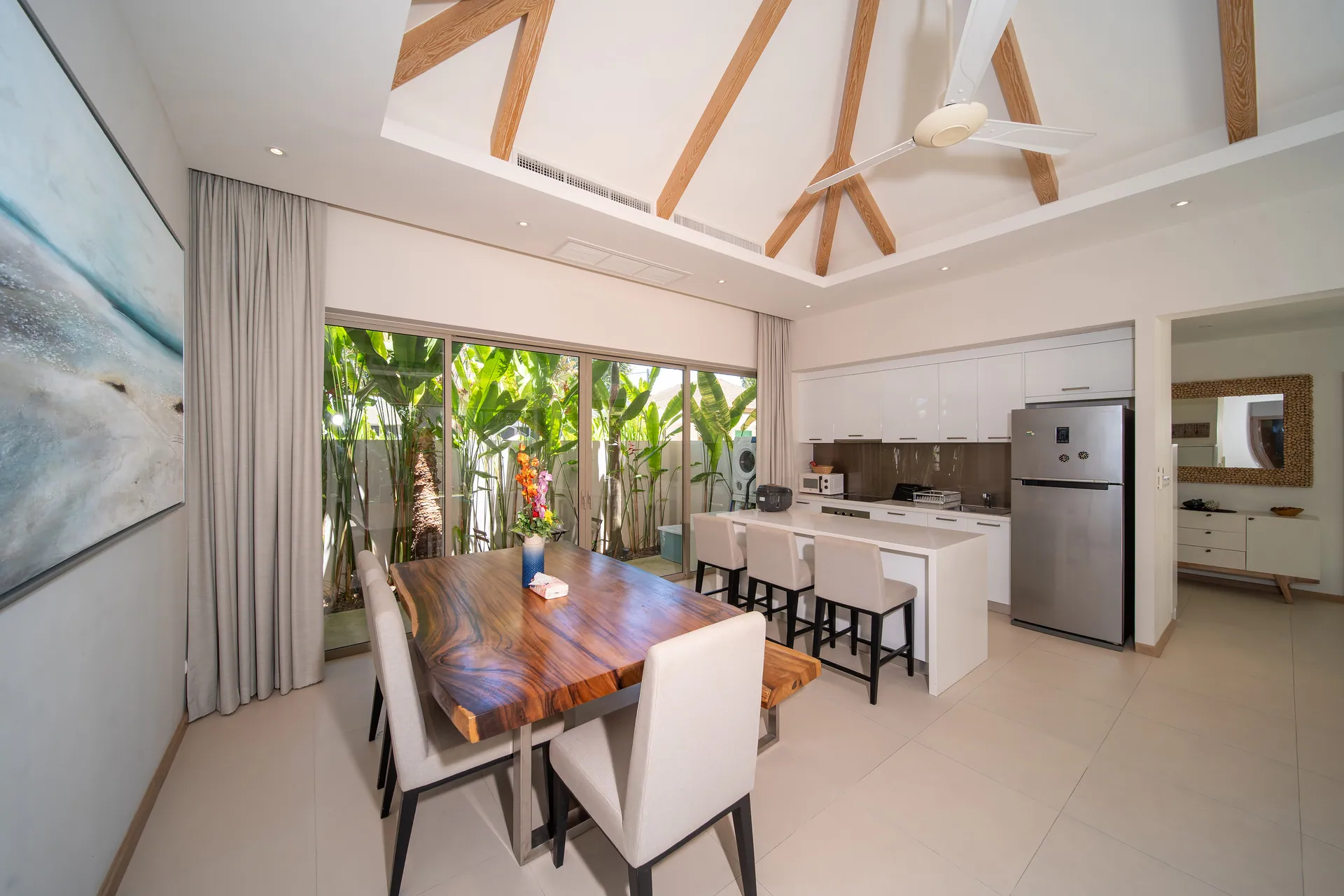 Solid-wood dining table beside the open kitchen and its breakfast bar