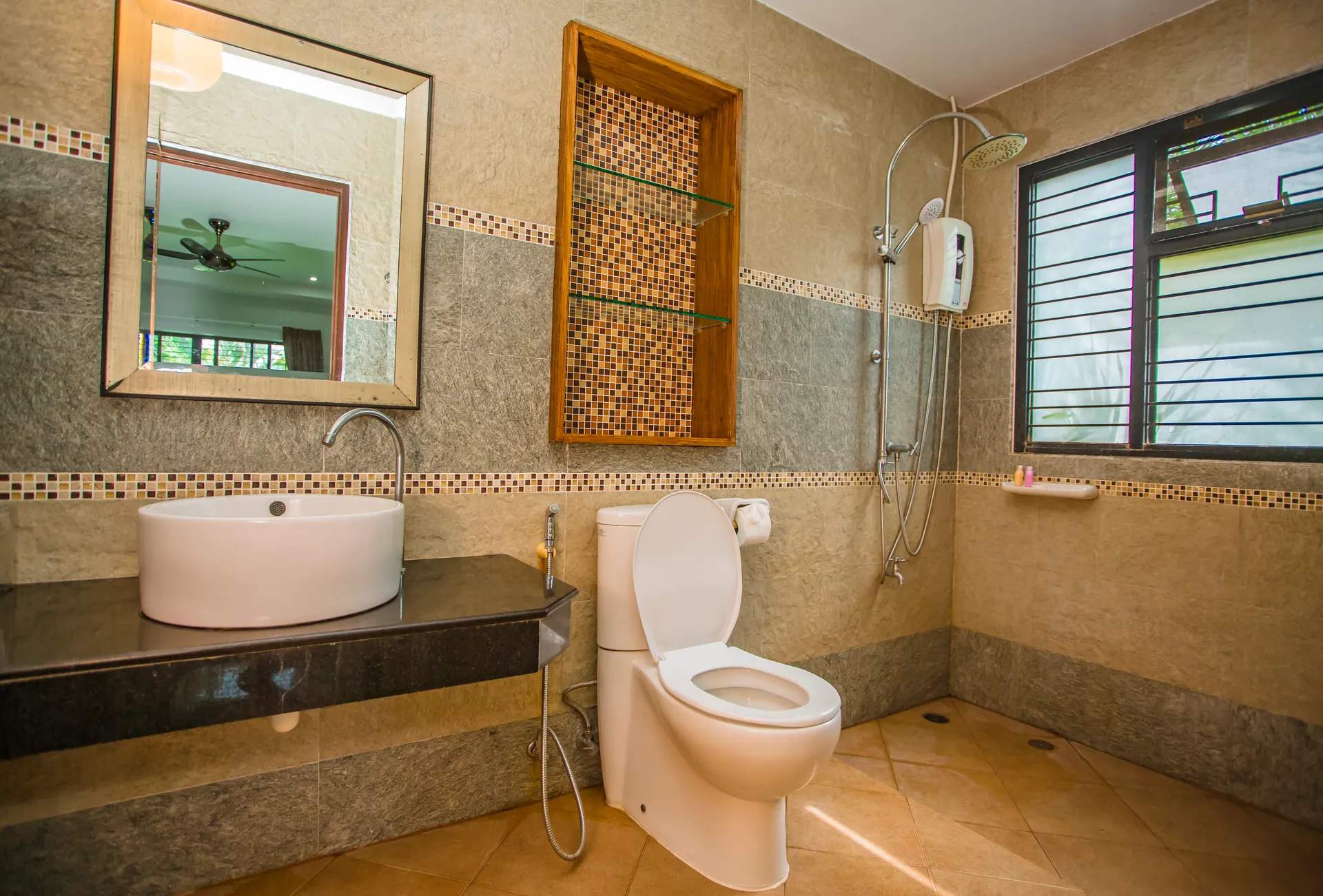 Bathroom with a walk-in rain shower, a round vessel basin and a mosaic-lined shelf niche