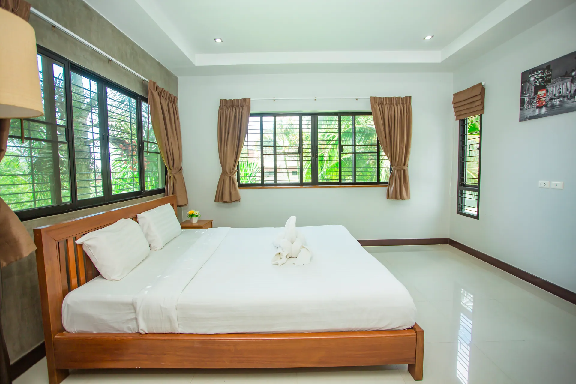 Spacious bedroom with a timber double bed and windows on three sides
