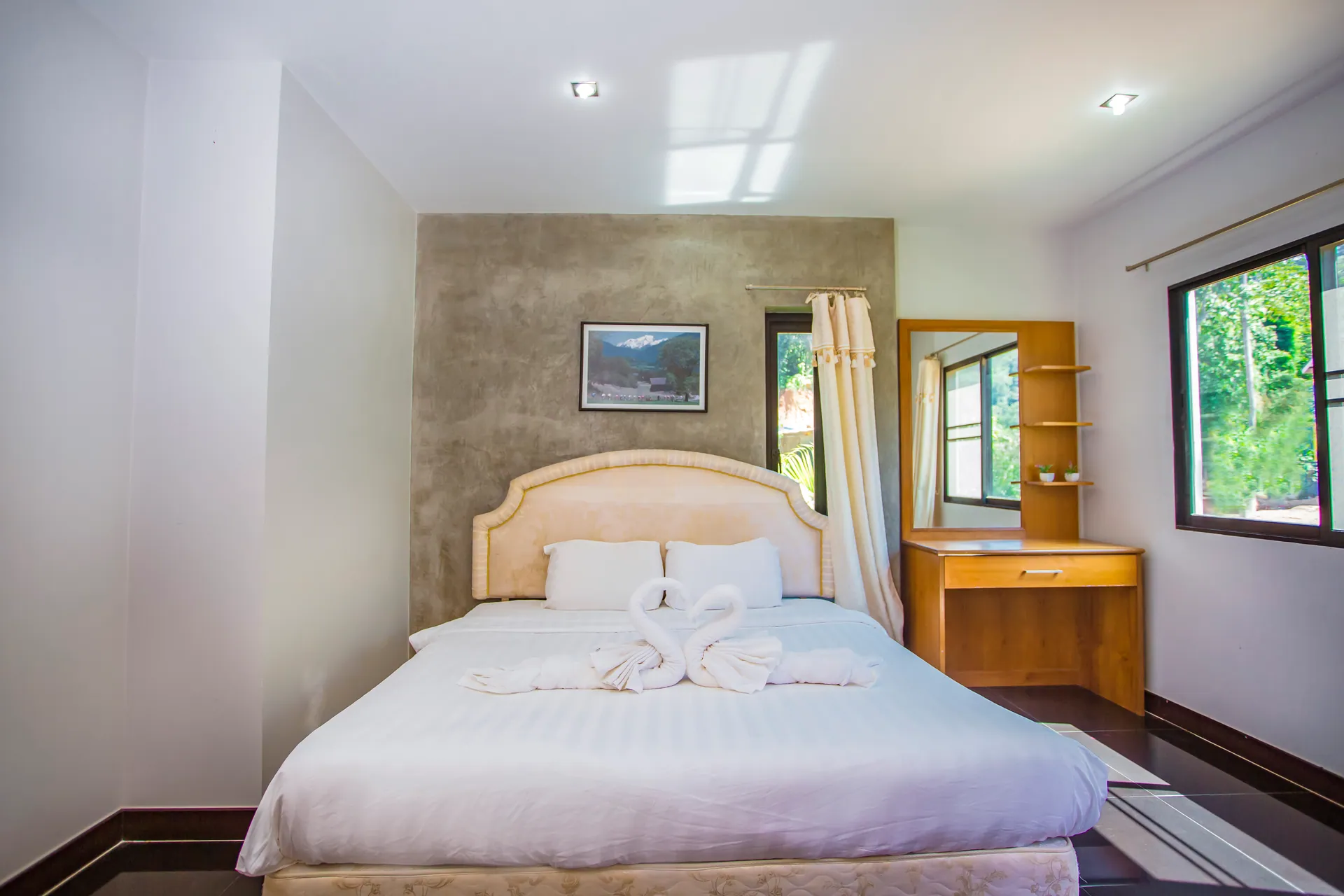 Bedroom with a double bed, an upholstered headboard and a timber dressing table