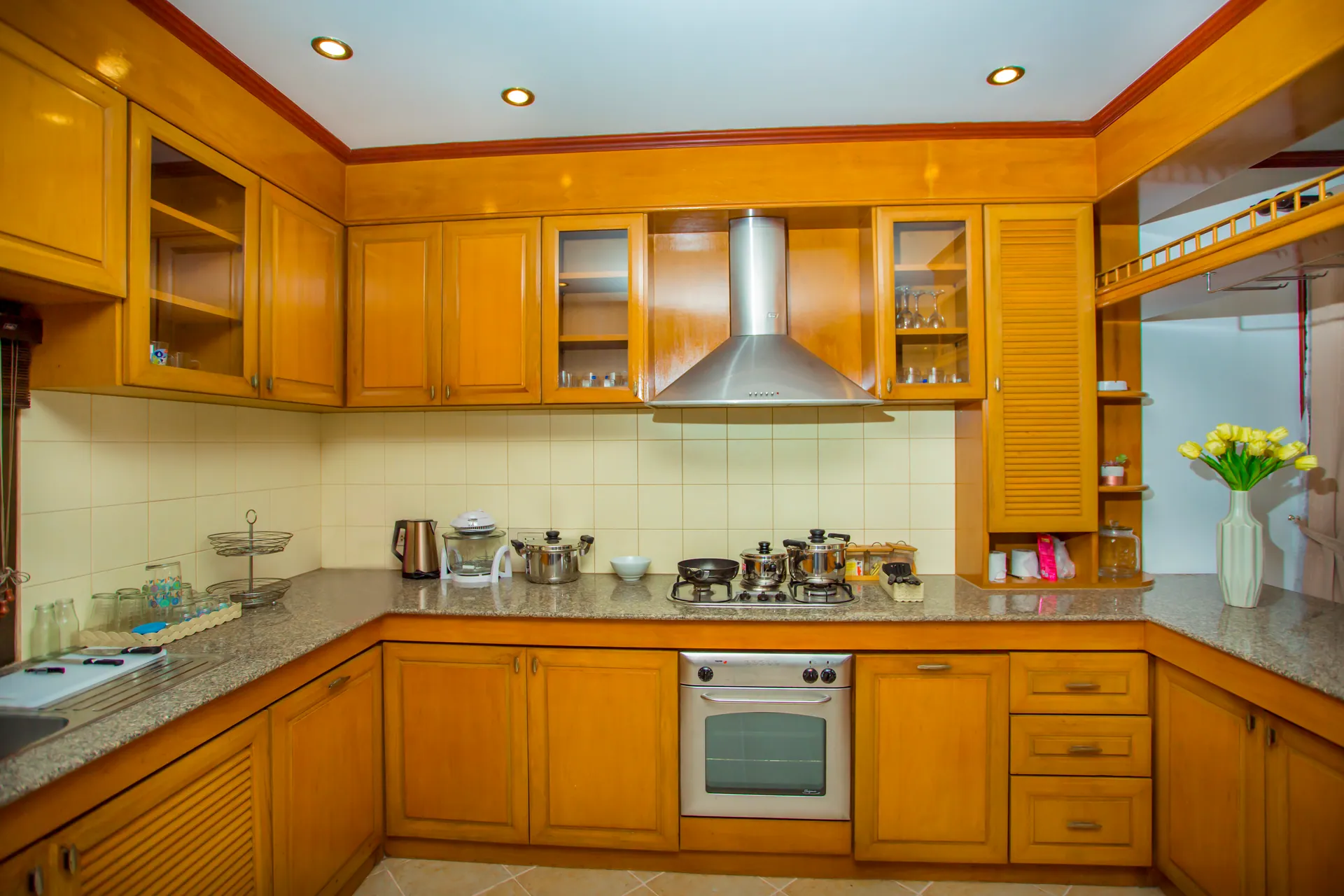 U-shaped timber kitchen with a gas hob, a built-in oven and a stainless-steel extractor hood