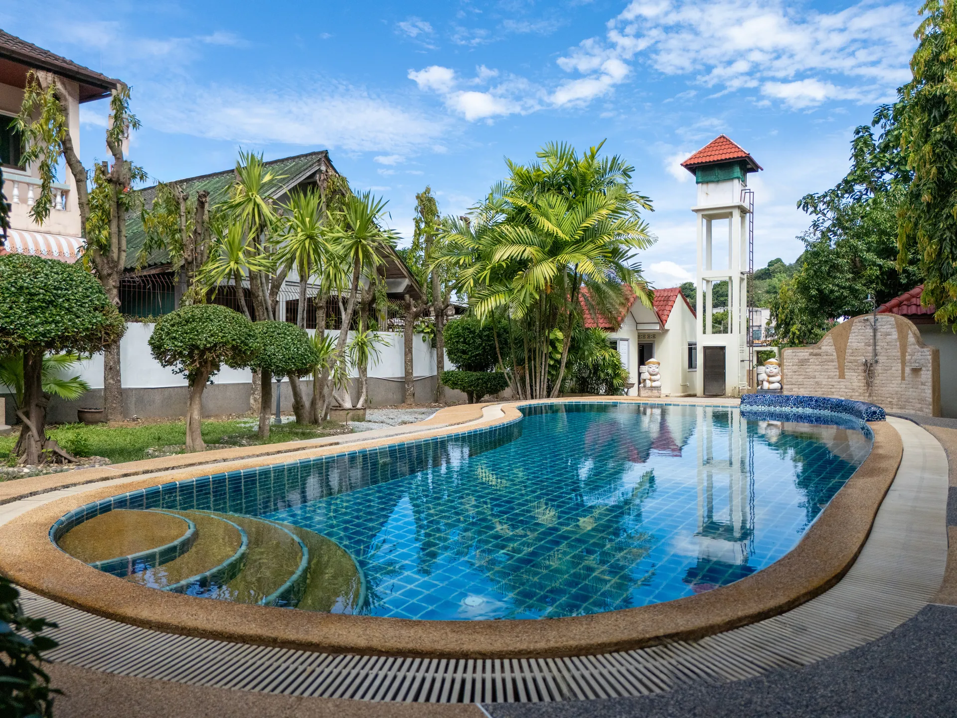 Wide curved steps leading into the pool, with palms reflected in the still water
