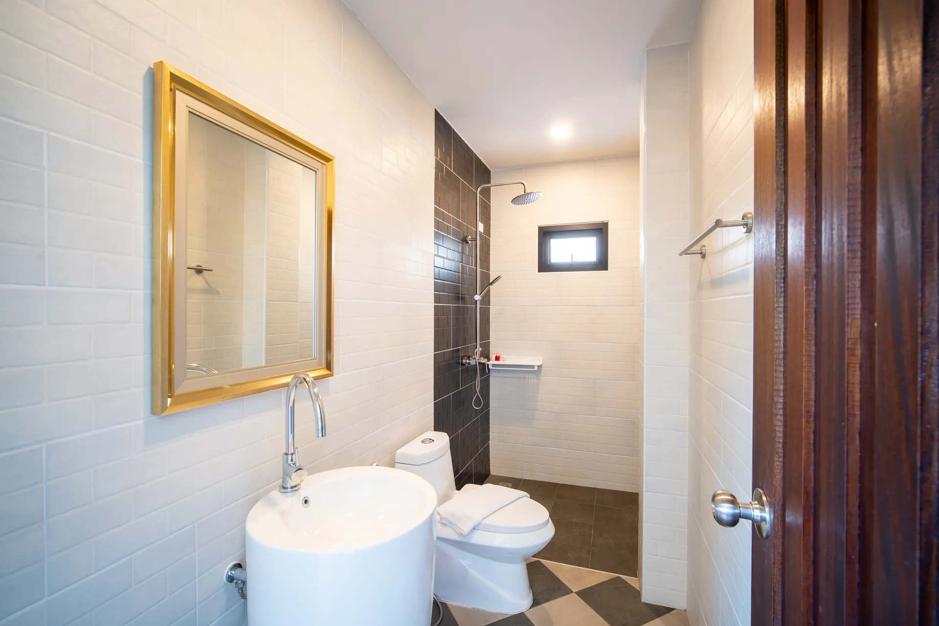 Bathroom with a round pedestal basin, a gilt-framed mirror and a walk-in rain shower