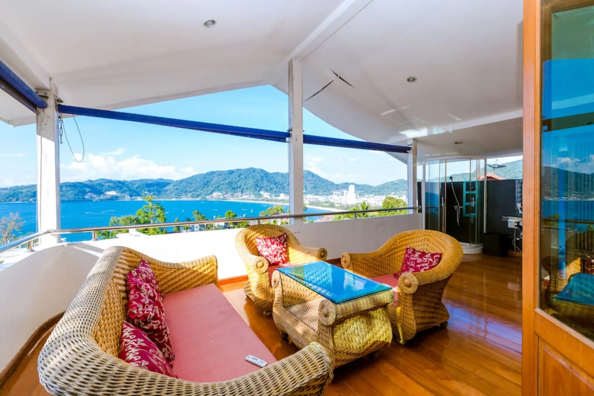 Covered terrace with a rattan sofa and armchairs, looking out across Patong Bay