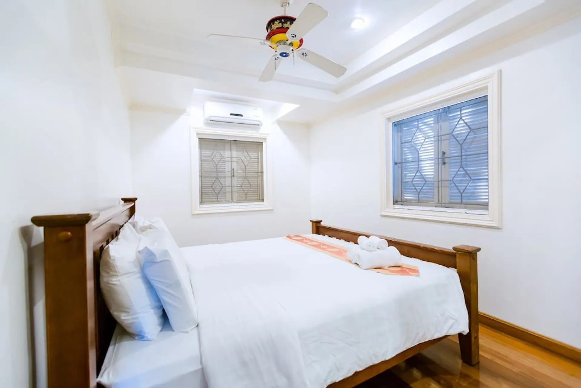 Bedroom with a timber bed, a ceiling fan and leaded lattice windows