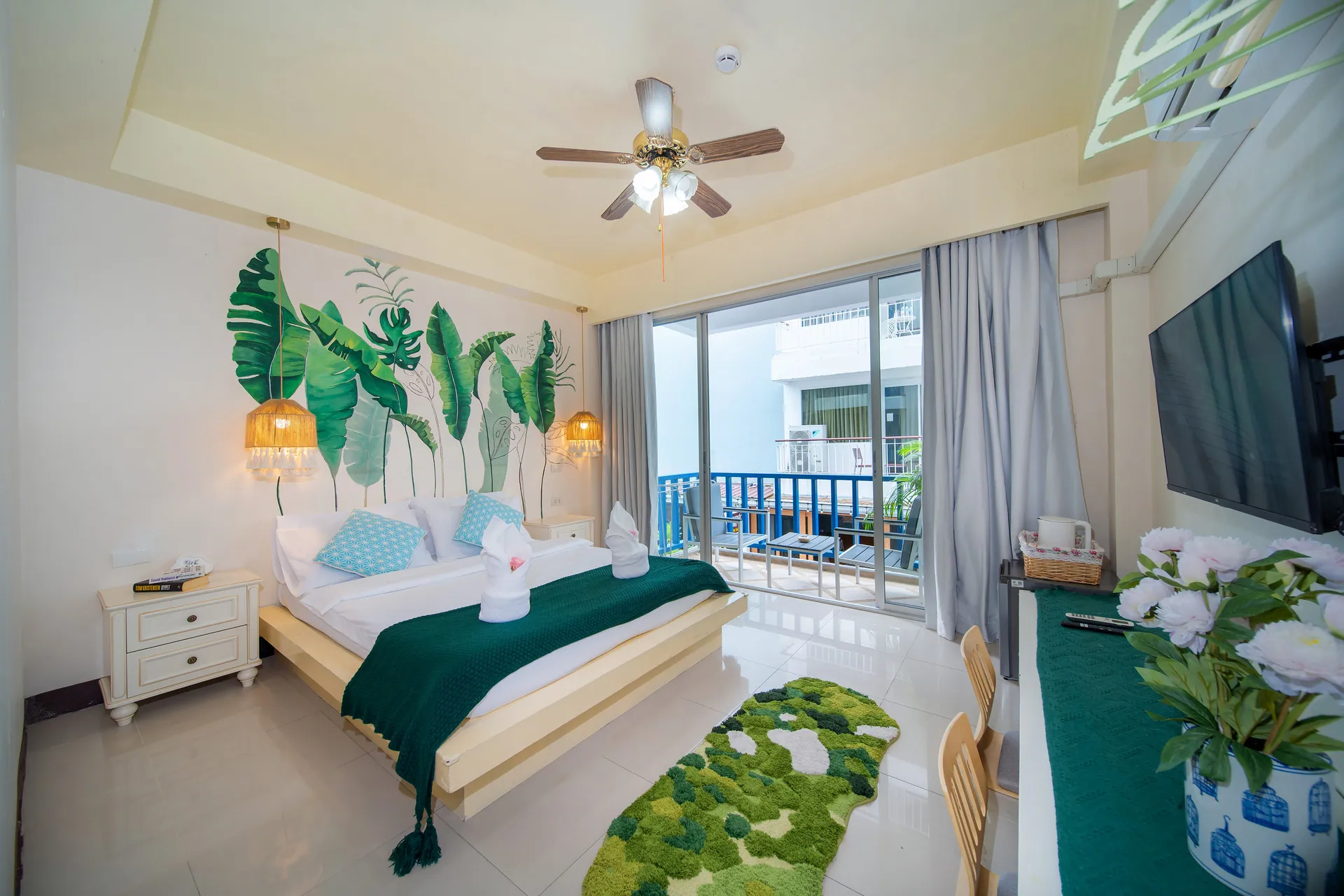 Superior Double Room with a double bed beneath a painted banana-leaf mural and a glass door to the balcony
