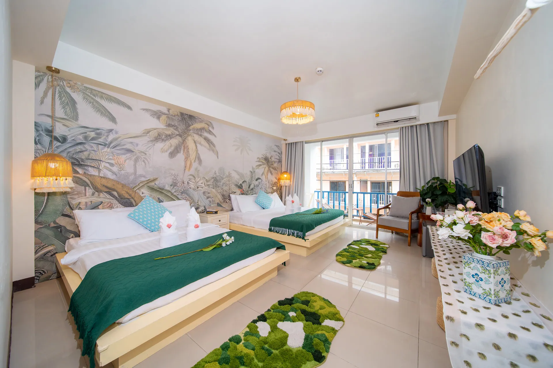 Deluxe Family Room with two double beds beneath a tropical palm wallpaper and a balcony door