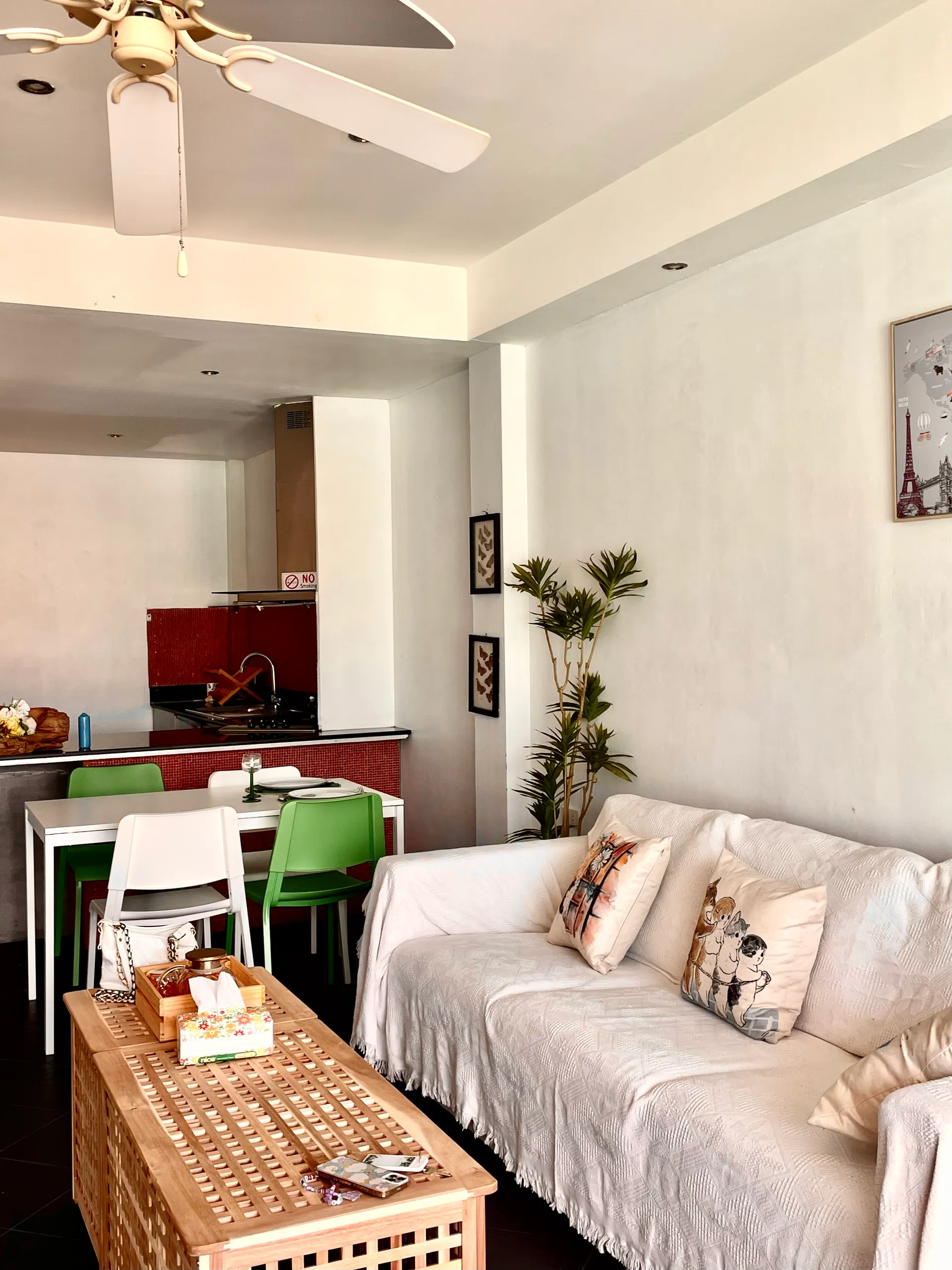 Suite living area with a white sofa, a wooden coffee table and a dining table by the kitchenette