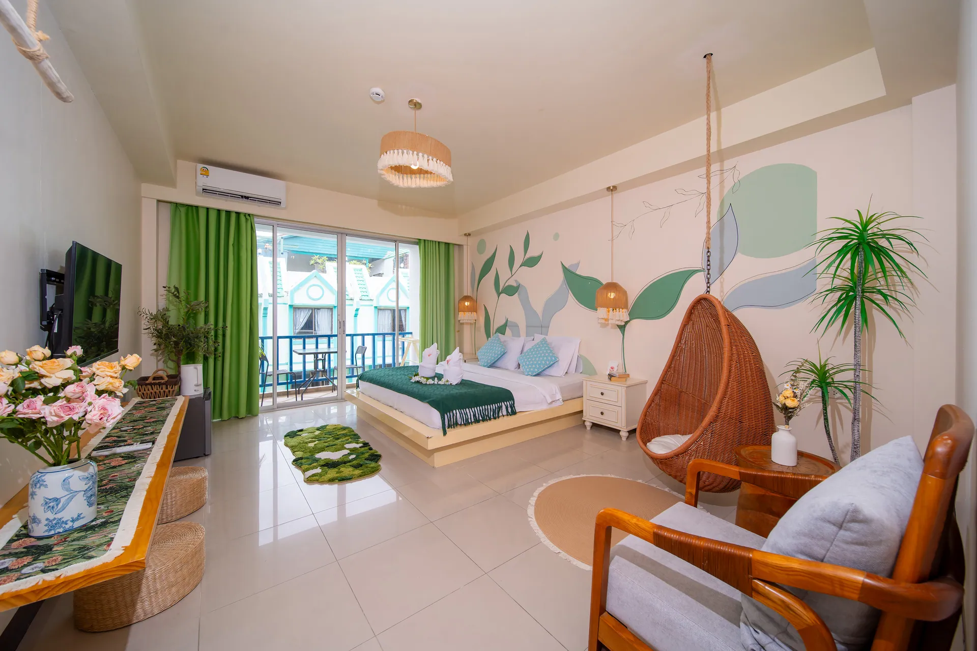 Deluxe Double Room with a hanging rattan egg chair, an armchair and a double bed by the balcony door