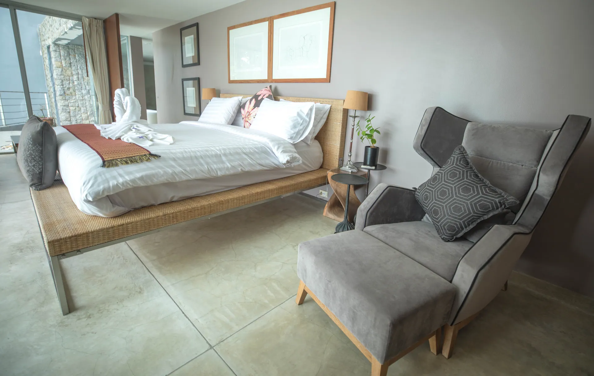 Pale grey bedroom with a platform bed and a grey wingback armchair