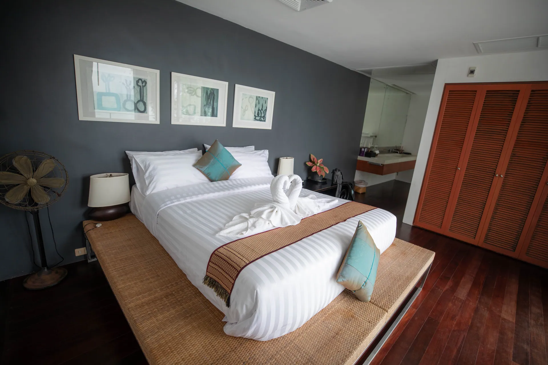 Bedroom with a charcoal feature wall, framed prints and a low platform bed