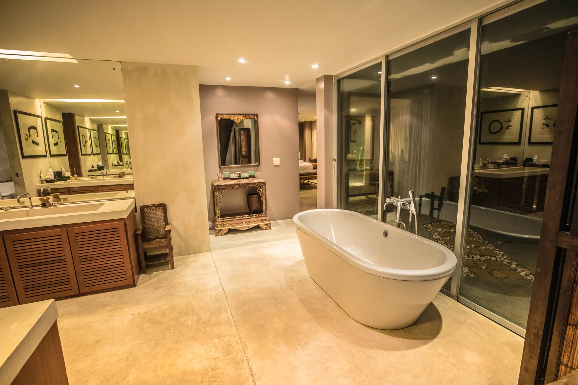 Bathroom with a freestanding bath, a timber vanity and glass partitions